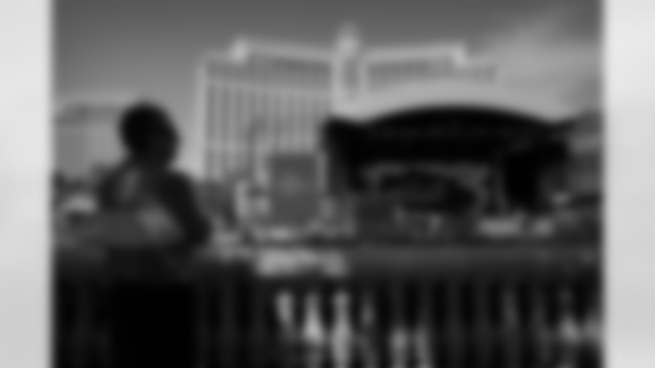 People look on as workers erect a stage during setup for the NFL draft Tuesday, April 26, 2022, in Las Vegas. (AP Photo/John Locher)