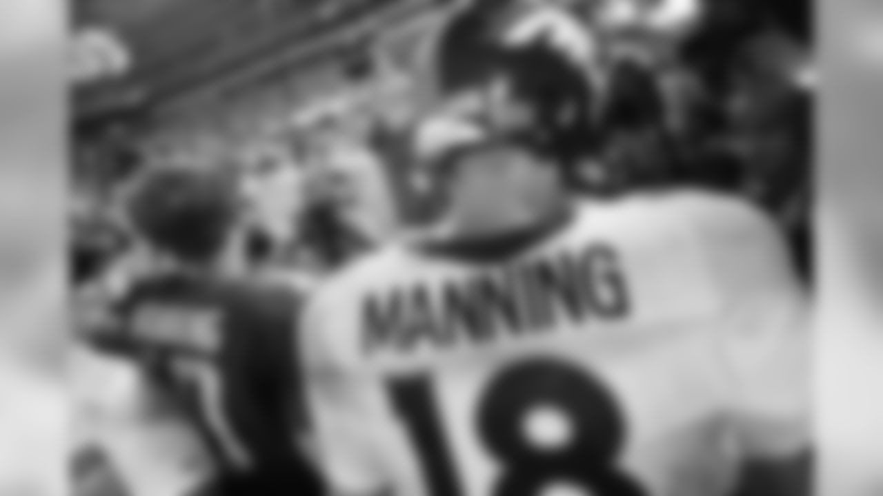 New York Giants' Eli Manning (10) shakes hands with his brother Denver Broncos quarterback Peyton Manning (18) during the second half of an NFL football game Sunday, Sept. 15, 2013, in East Rutherford, N.J. The Broncos won the game 41-23. (AP Photo/Kathy Willens)