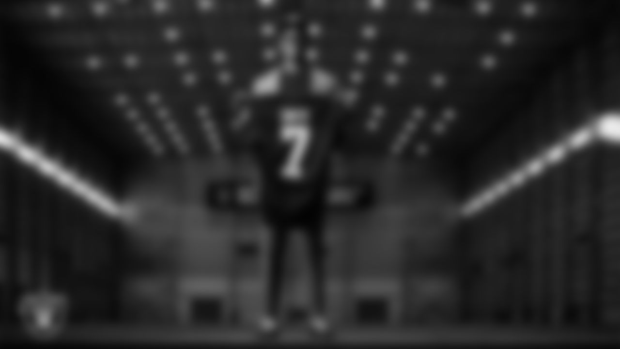 Quarterback Geno Smith poses for a photo on the indoor field after signing an extension with the Raiders at Las Vegas Raiders Headquarters.